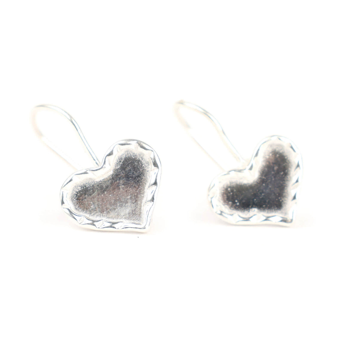 Heart-shaped silver earrings on a white background