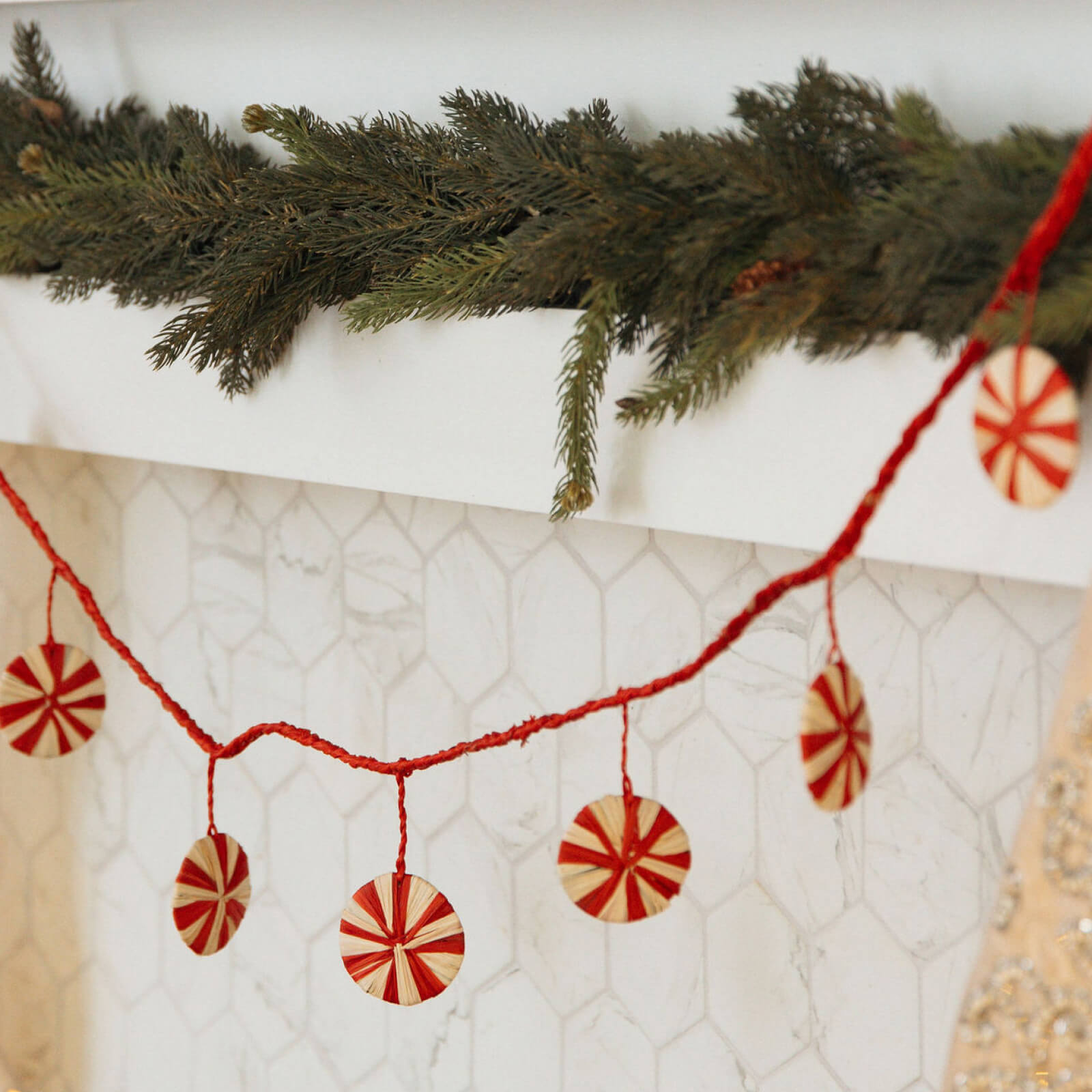 Decorative Christmas garland with red and white candy cane ornaments on a textured wall.