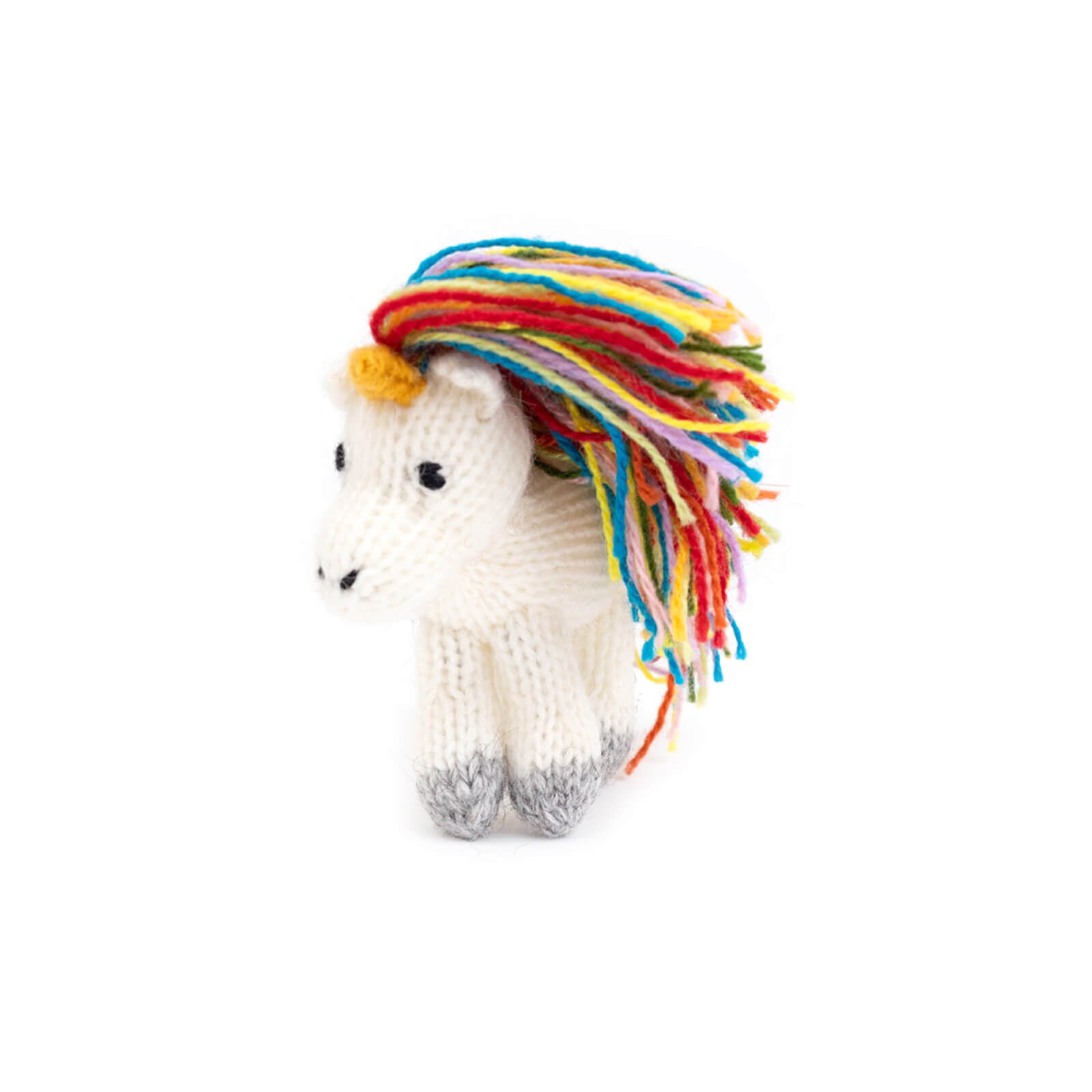 Knitted unicorn toy with colorful mane on a white background