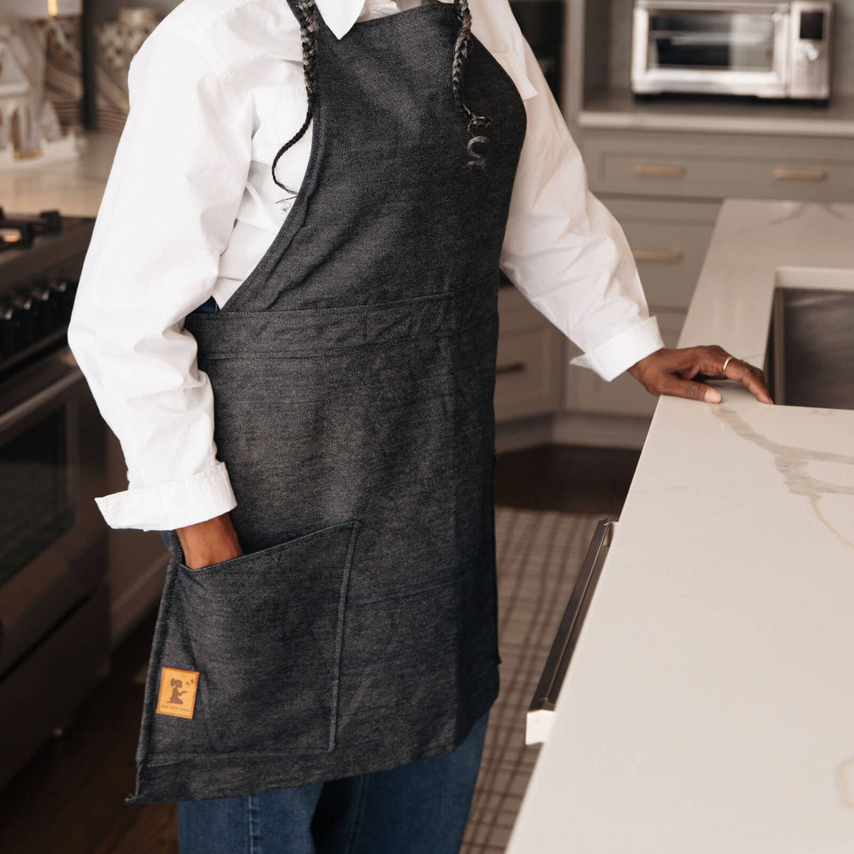 Person wearing a dark apron in a kitchen setting
