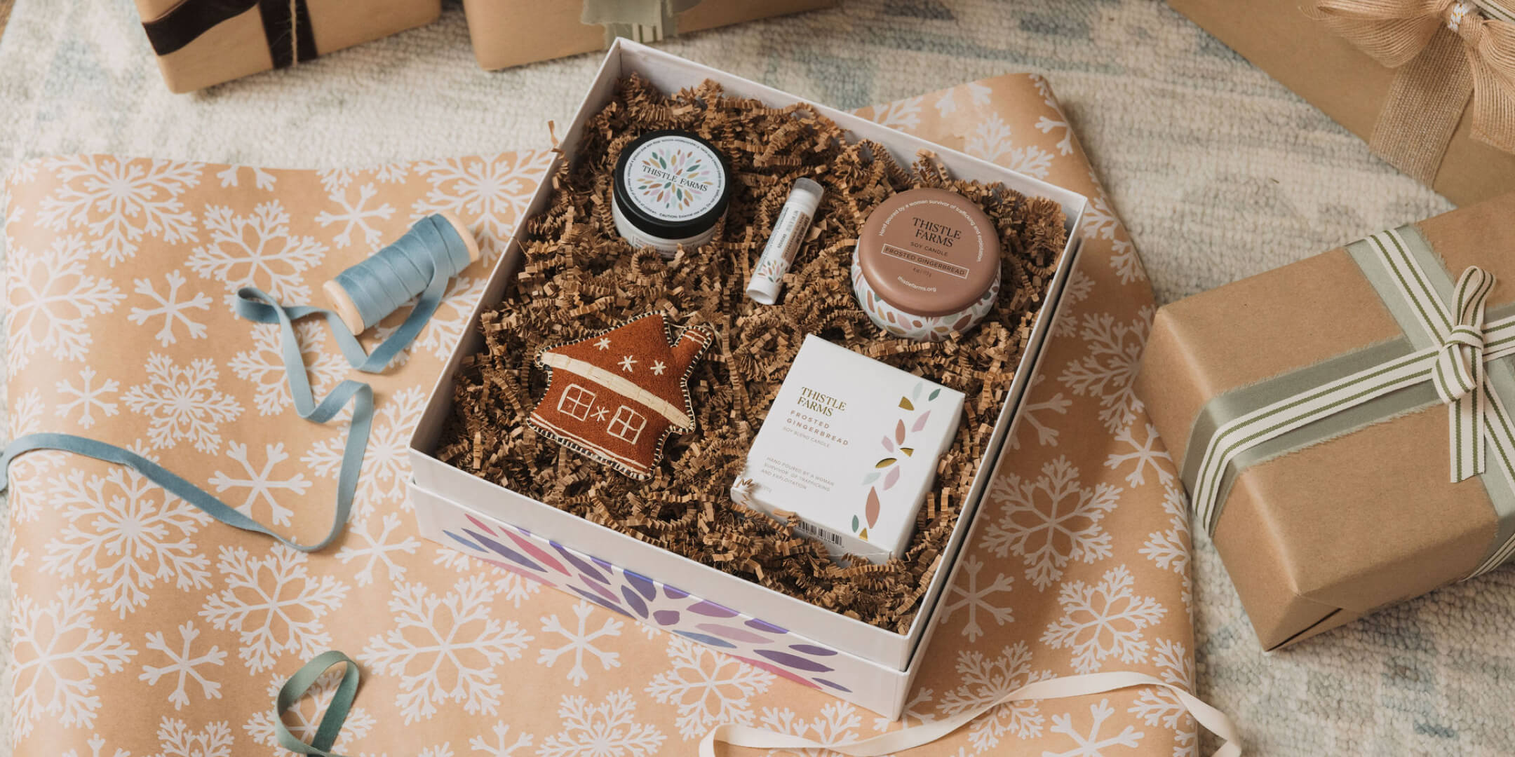 Gift box with products on a decorative surface with ribbons and gift wrap.