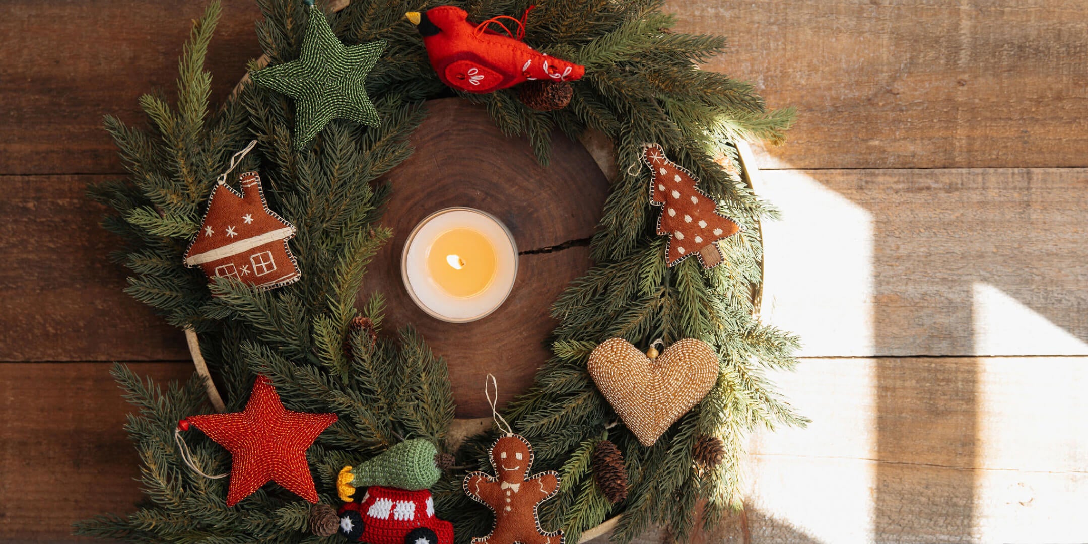 Decorative Christmas wreath with a candle, stars, and gingerbread men on a wooden background