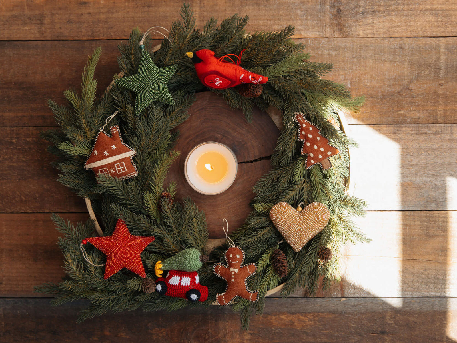 Decorative Christmas wreath with candles and ornaments on a wooden background
