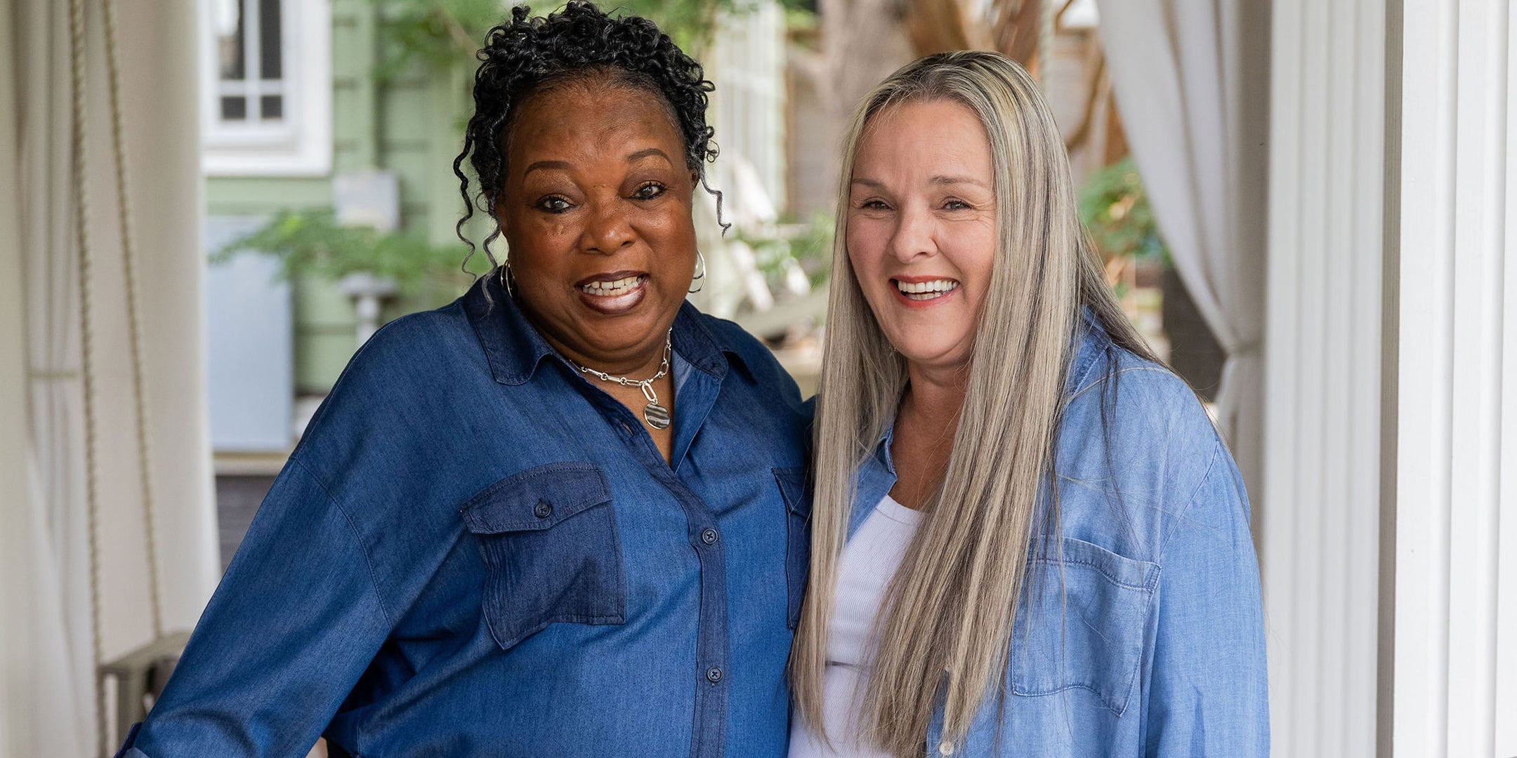 Two Thistle Farms women standing together outdoors, wearing blue shirts.