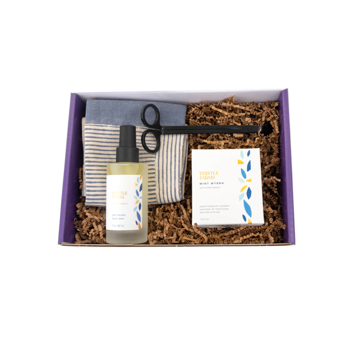 Gift set with a bottle, striped towel, and candle in a purple box.