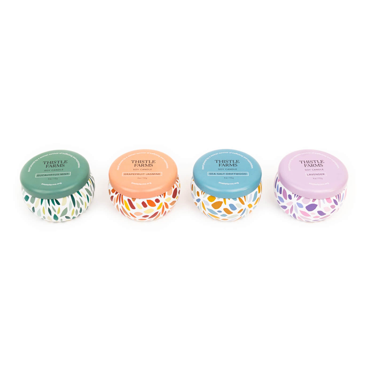 Four small jars with colorful lids and decorative patterns on a white background