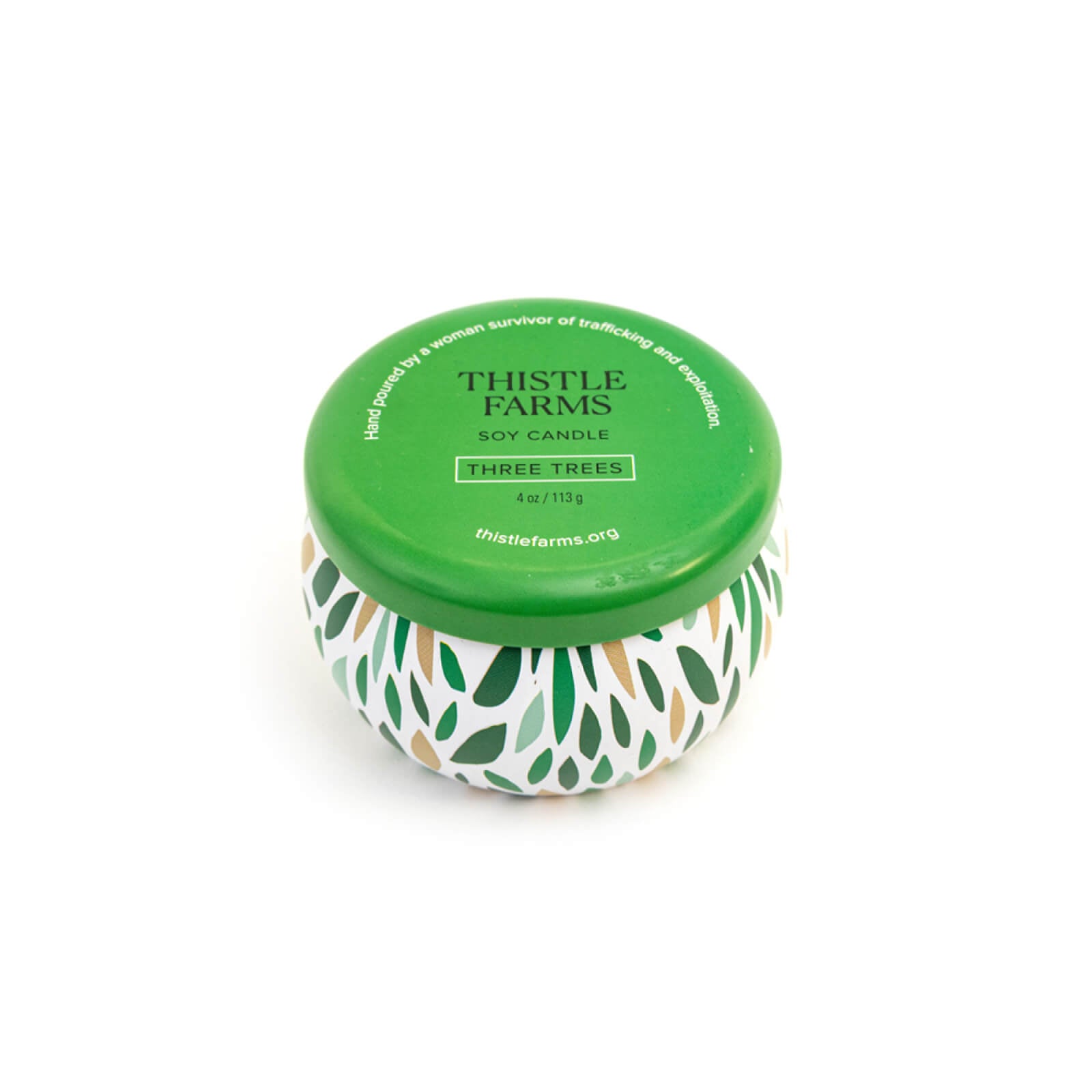 Thistle Farms candle with green lid and leaf pattern on a white background