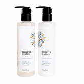Two bottles of Thistle Farms hand soap and lotion on a white background