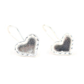 Heart-shaped silver earrings on a white background