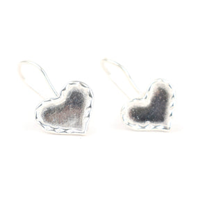 Heart-shaped silver earrings on a white background