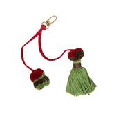 Red and green tassel keychain with a gold clasp on a white background