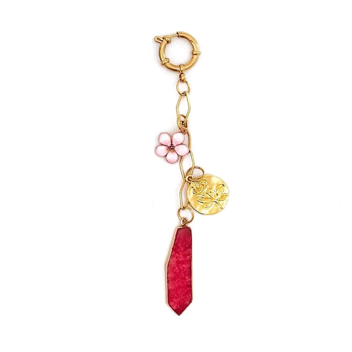 Gold hoop earring with pink flower and red stone charm on a white background