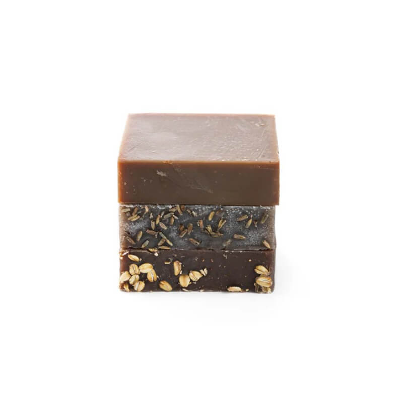 Handmade bar soaps with visible layers on a white background