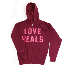 Maroon hoodie with 'LOVE HEALS' text in pink on a white background