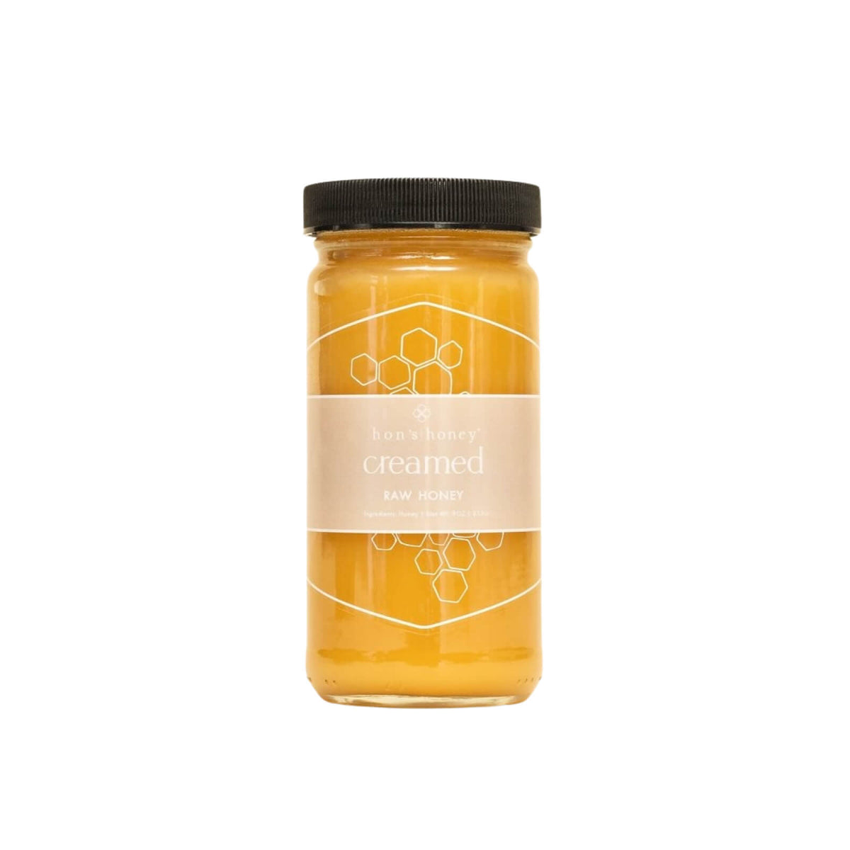 Jar of honey with a black lid on a white background