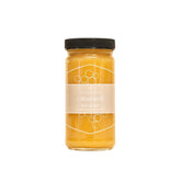 Jar of honey with a black lid on a white background