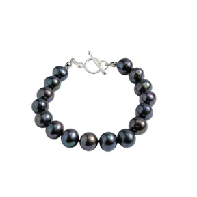 Black pearl bracelet with silver clasp on a white background