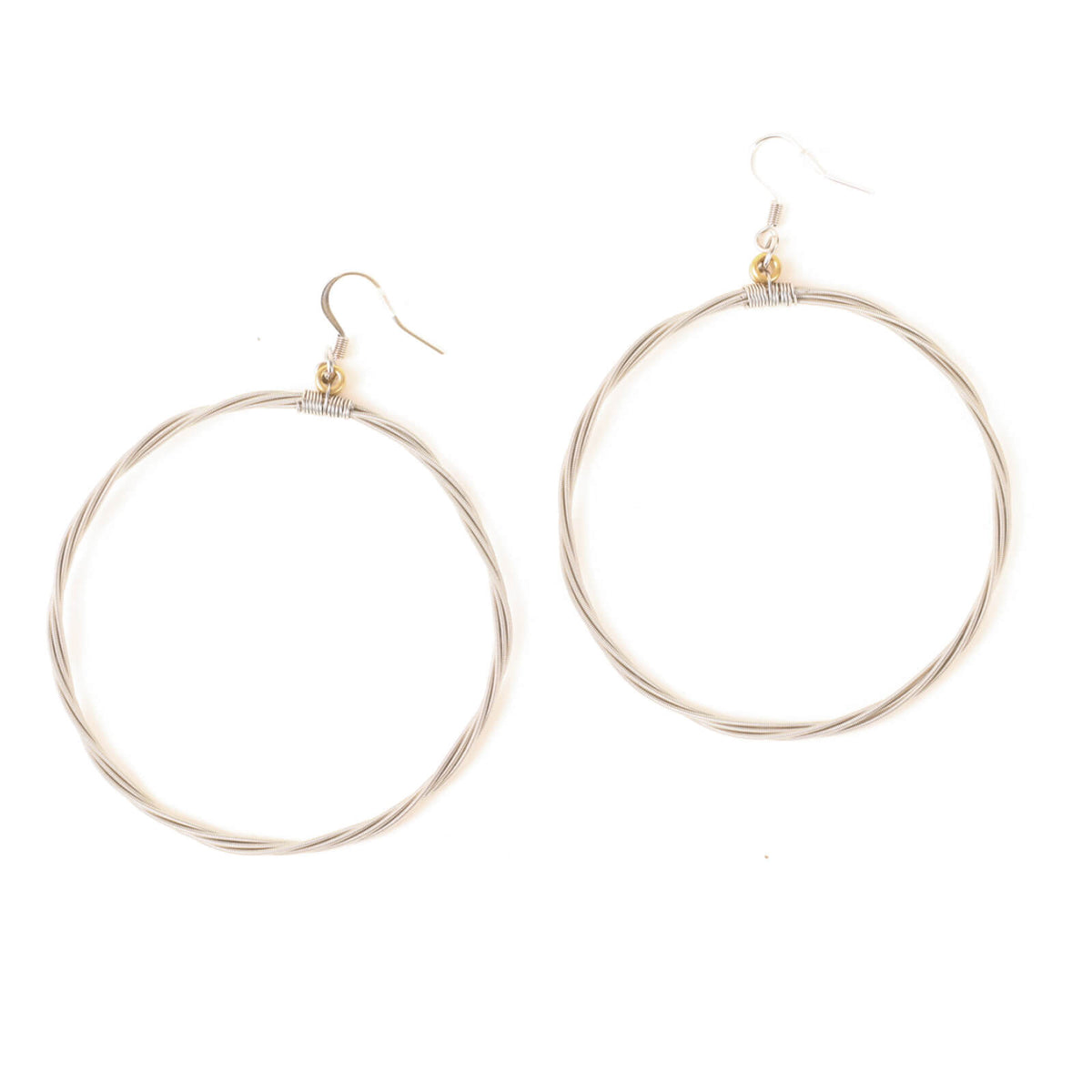 Silver hoop earrings made of guitar strings on a white background