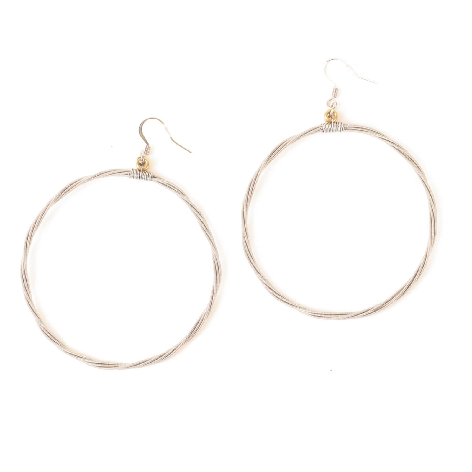 Silver hoop earrings made of guitar strings on a white background