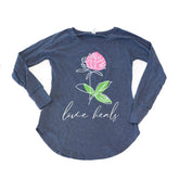 Blue long-sleeve shirt with a pink flower and 'love heals' text on a white background