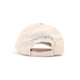 Beige cap with 'Thistle Farms' logo on a white background