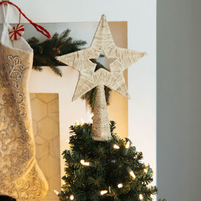 Decorative star on a Christmas tree with stockings in the background