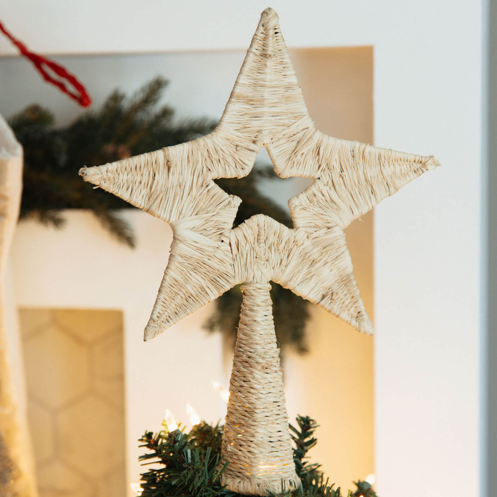 Decorative star ornament on a Christmas tree with a blurred background
