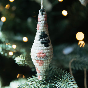 Decorative Christmas ornament on a tree with blurred lights in the background