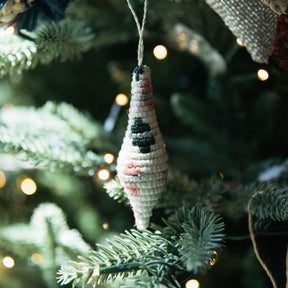 Decorative shell ornament hanging on a Christmas tree with blurred lights in the background