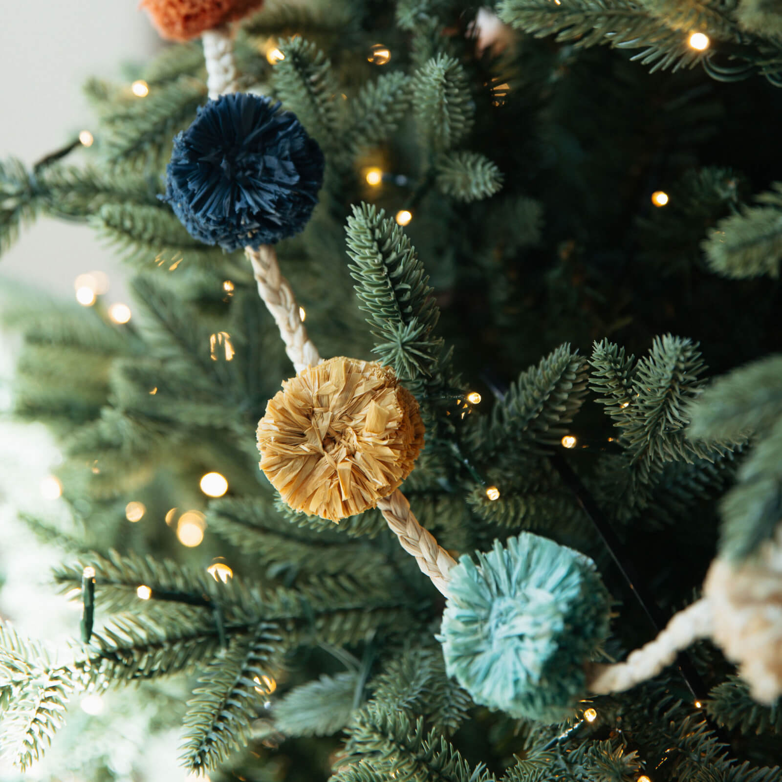 Decorative garland with pom-poms on a Christmas tree