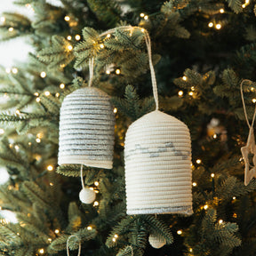 Decorative hanging ornaments on a Christmas tree with lights.
