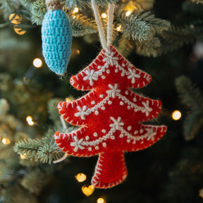 Red Christmas tree ornament with white snowflakes on a decorated tree