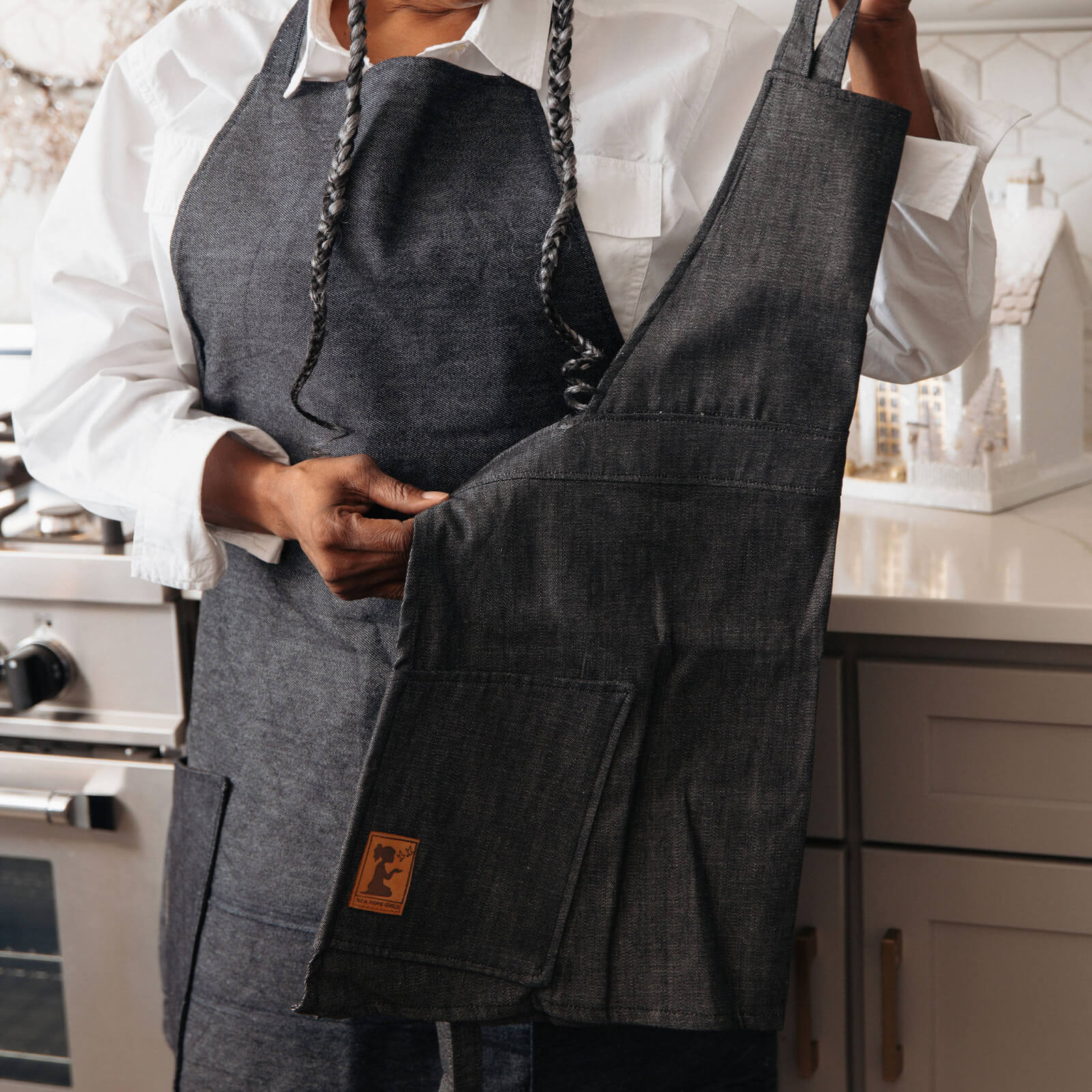 Person wearing a dark denim apron in a kitchen setting