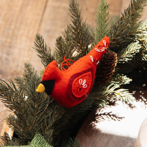Red cardinal bird ornament on a branch with a blurred background