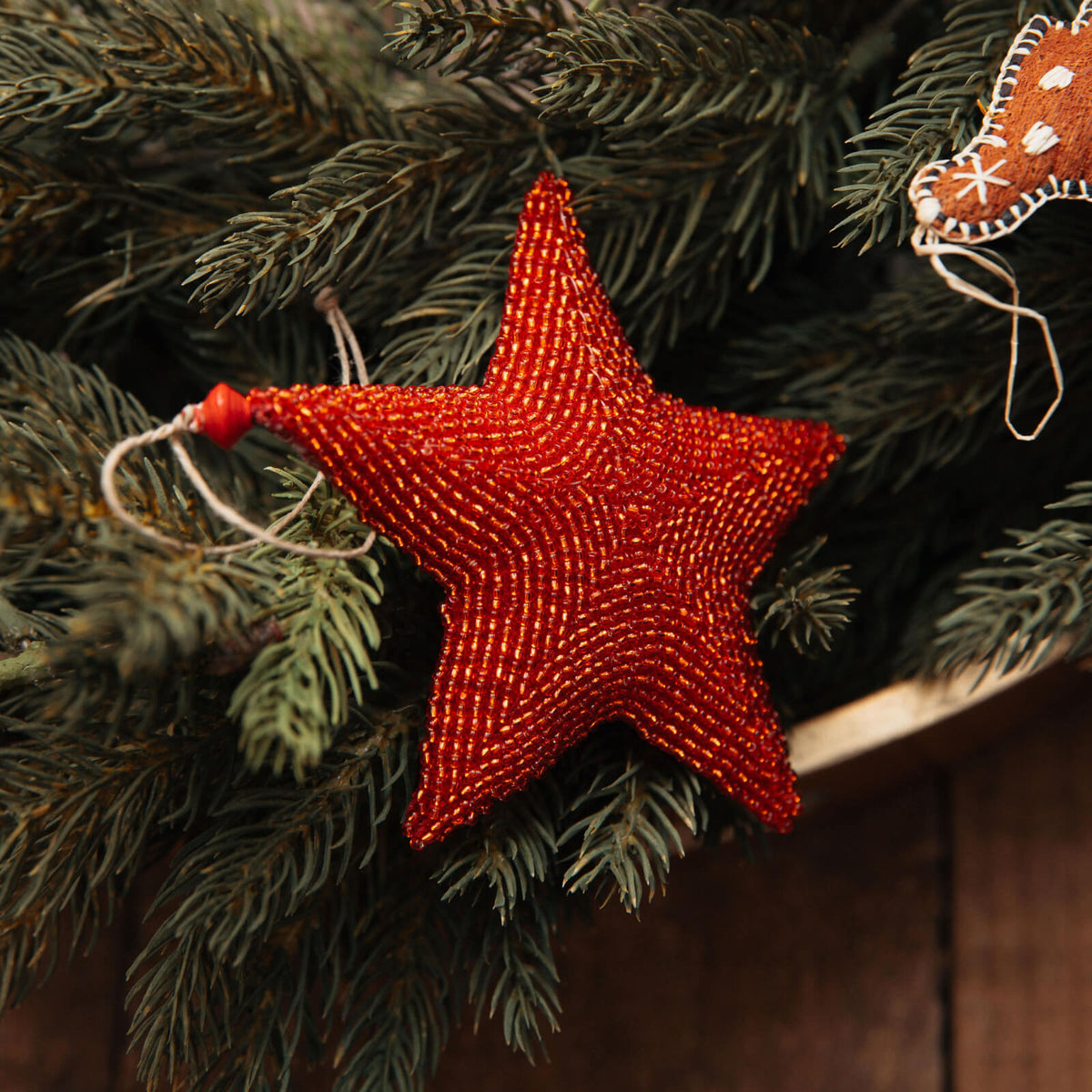 Red beaded star ornament on a Christmas tree