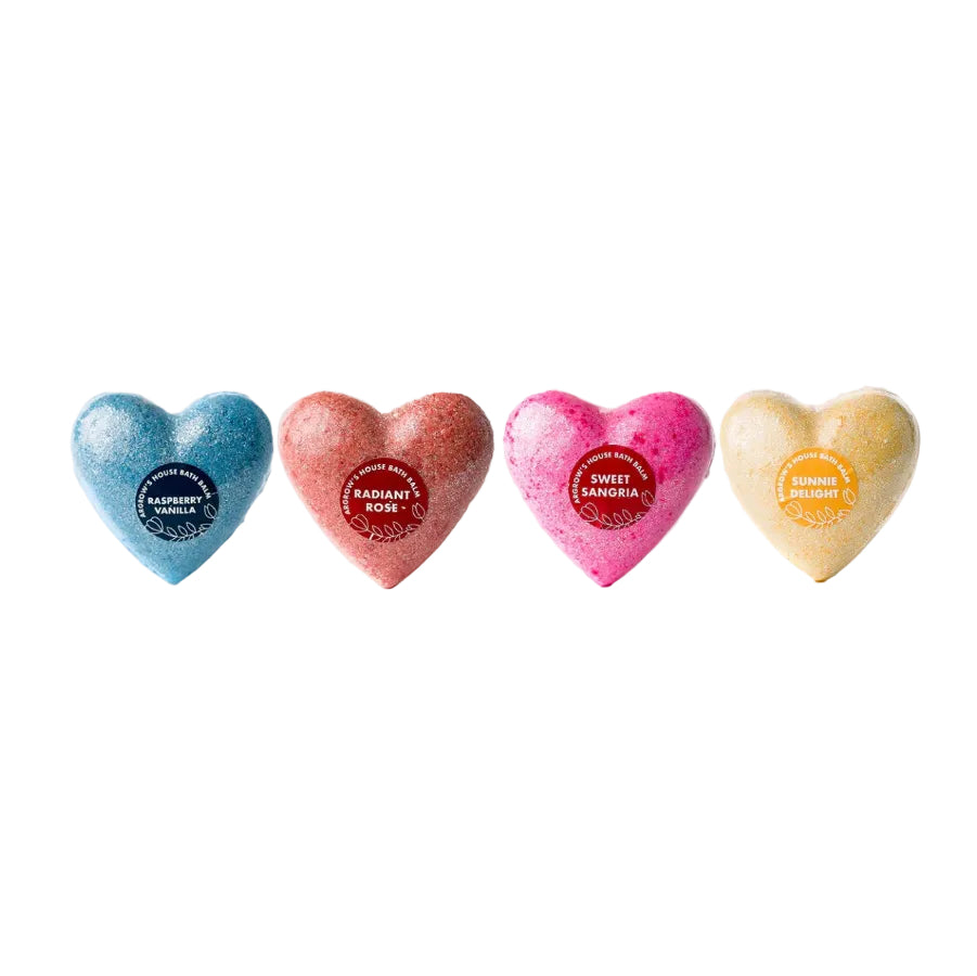 Agrow House made heart shaped bath bombs lined up horizontally from left to right is dark blue for Raspberry Vanilla, dusty red for Radiant Rose, hot pink for Sweet Sangria, and yellow for Sunnie Delight.