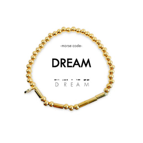Gold beaded bracelet with 'DREAM' text on a white background