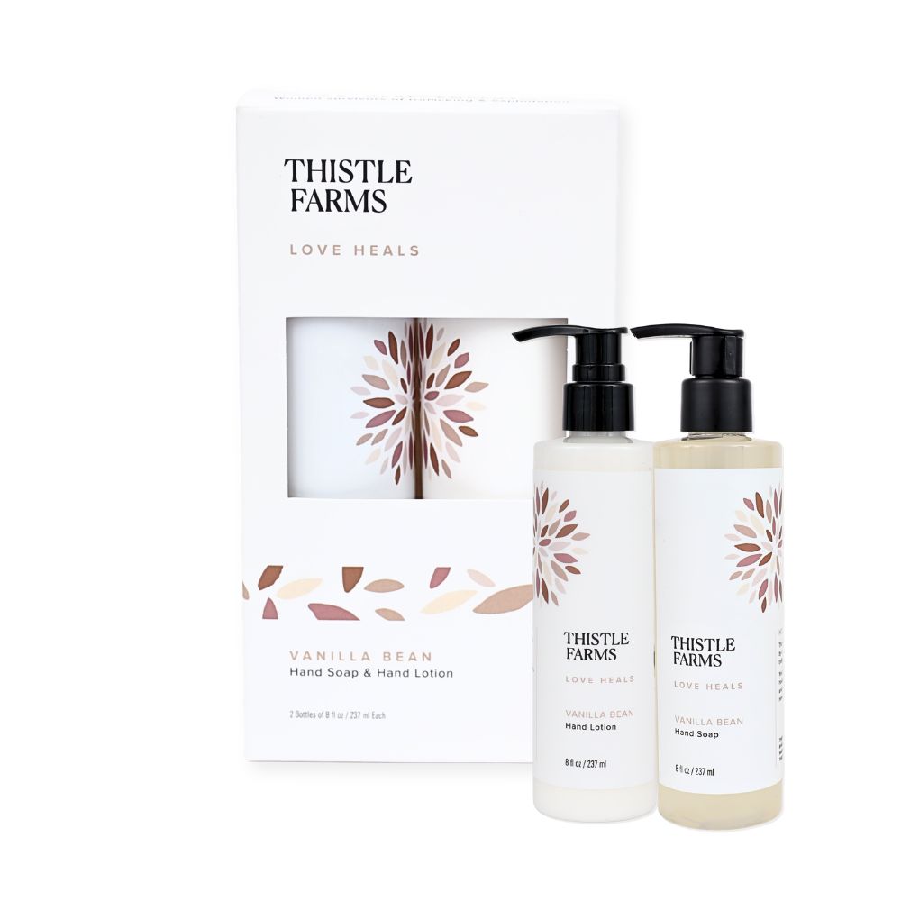 Thistle Farms Love Heals Vanilla Bean Hand Soap and Hand Lotion set, featuring two pump bottles with black caps and a matching white gift box with a window.