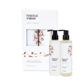 Thistle Farms Love Heals Vanilla Bean Hand Soap and Hand Lotion set, featuring two pump bottles with black caps and a matching white gift box with a window.