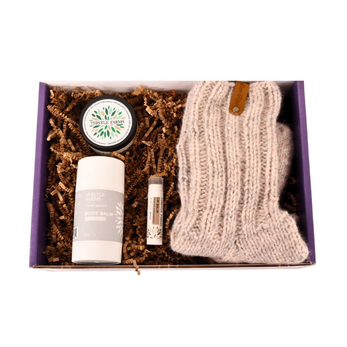 Gift set with knit socks, lip balm, body butter, and body balm in a gift box.
