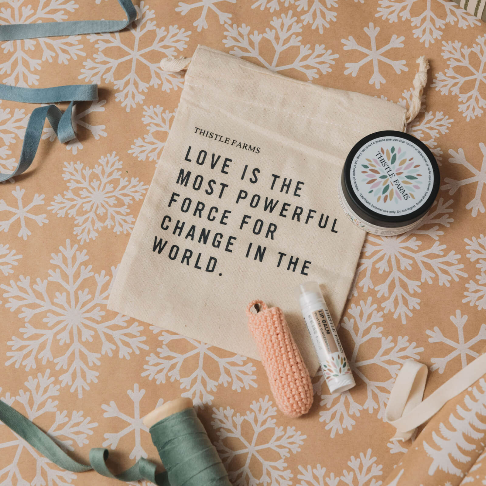 Product set with 'Thistle Farms' pouch bag and products on a patterned background