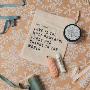 Product set with 'Thistle Farms' pouch bag and products on a patterned background
