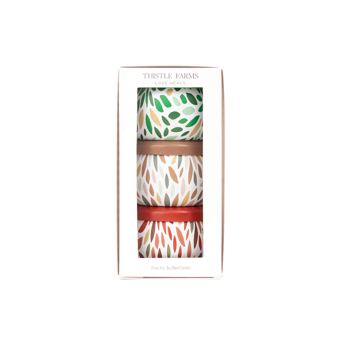 Three patterned candles in a box with 'Thistle Farms' branding on a white background.