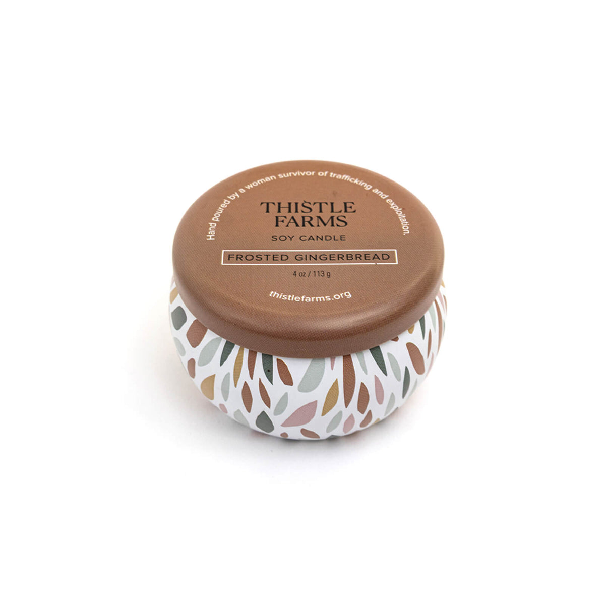 Thistle Farms soy candle with brown lid and leaf pattern on a white background