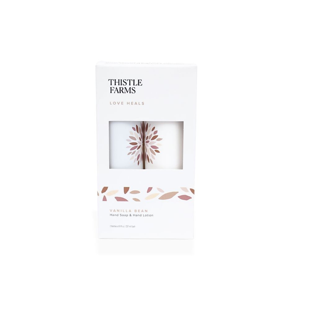 Thistle Farms Love Heals Vanilla Bean Hand Soap & Hand Lotion set in a white rectangular box with a clear window showing the white soaps inside, on a white background.