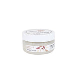 A small clear plastic jar of Vanilla Bean Sugar Scrub with a white screw-on lid and a white label featuring a floral design, set against a plain white background.
