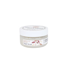 A small clear plastic jar of Vanilla Bean Sugar Scrub with a white screw-on lid and a white label featuring a floral design, set against a plain white background.